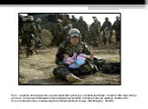 Врач морской пехоты держит на руках иракскую девочку в центральном Ираке 29 марта 2003 года. Когда местные солдаты начали вытеснять гражданских жителей в сторону позиций морских пехотинцев, перекрестный огонь на линии фронта разбил иракскую семью. (Damir Sagolj / Reuters)