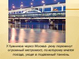 У Лужников через Москва- реку перекинут огромный метромост, по которому мчатся поезда, уходя в подземный тоннель.