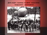 Дети водят хоровод на фоне аэростатов воздушного заграждения.